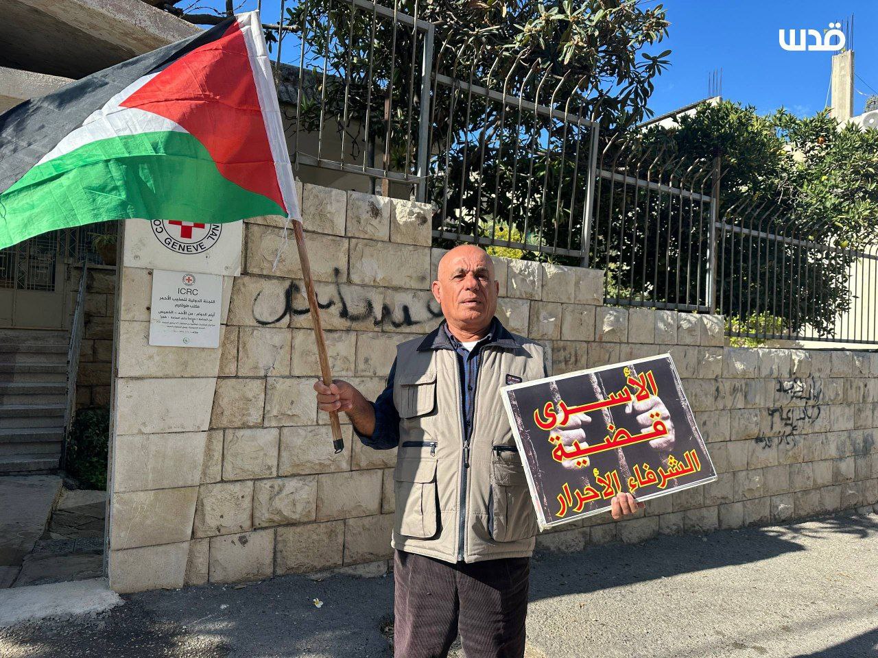 ناشطان يقفان أمام مقر الصليب الأحمر في طولكرم مطالبَين بالتحرك لإنقاذ الأسرى