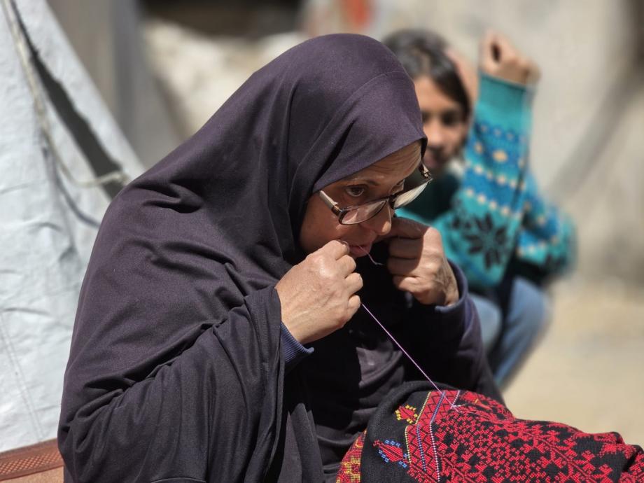 سُهيلا بني عيسى تتحدى النزوح بتطريز الفساتين التراثية 